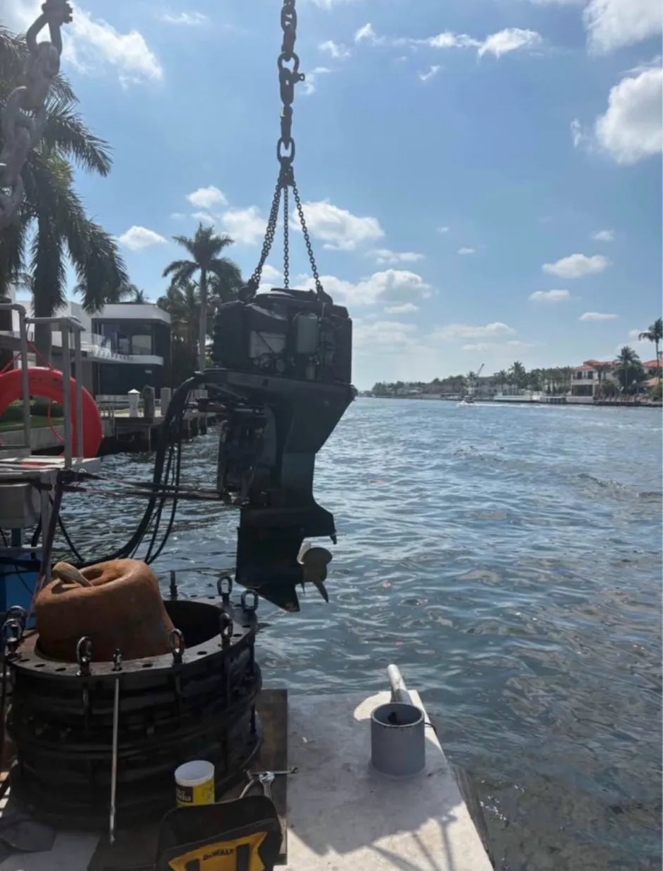 Outboard engine hoisted dockside for repair